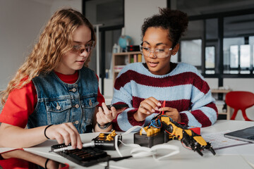 High school students working on robotics project, using online AI app to answer questions.