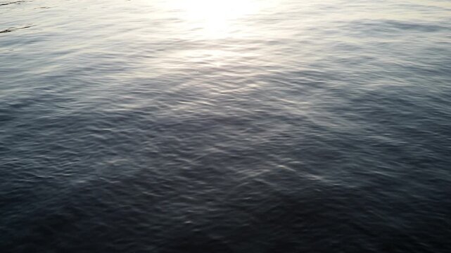 Experience serene reflections on Lake Onega as sunlight dances on water surface in Karelia. Peaceful atmosphere invites relaxation and contemplation. Gentle ripples create mesmerizing reflections