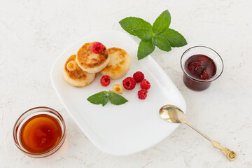 Curd fritters with raspberries, strawberry jam and honey.