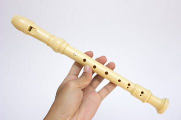 A recorder flute isolated on white background. A recorder flute is an end-blown woodwind instrument with a whistle-like mouthpiece, seven finger holes, and a thumbhole. © daniel limantara