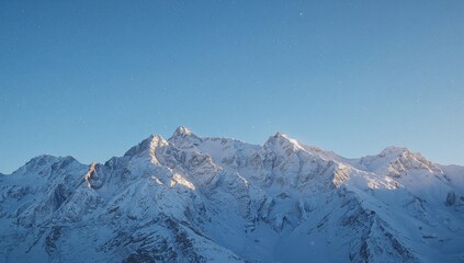 Obraz premium Snowy mountain landscape under a clear blue sky, showcasing seasonal change