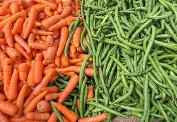 Fresh carrots and green beans displayed side by side at a market, showing natural and healthy vegetables. Ideal for food, farming, and grocery-related use. Date: 24.11.2025