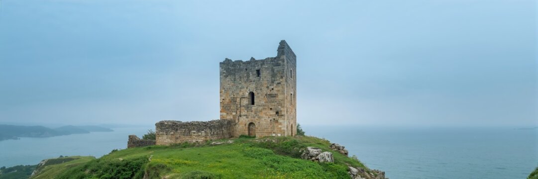 Partially reconstructed medieval fortress tower and walls on the Kaliakra Peninsula, emphasizing preservation efforts