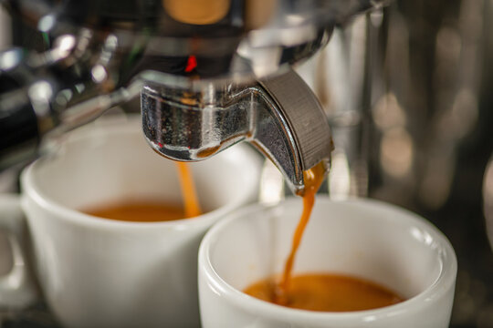 Coffee machine in cafe to brew fresh espresso. Close up detail showing steam, crema, and aroma of professional preparation.