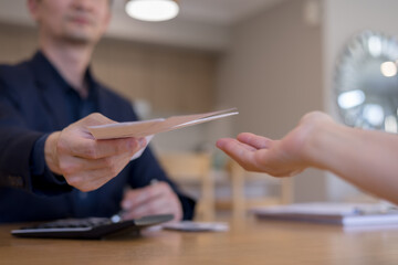 businessman handing over documents to another person. Concept of office communication, approval process, file exchange, business workflow teamwork in a professional setting.
