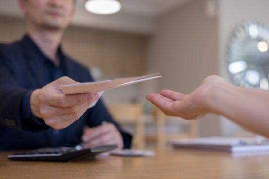 businessman handing over documents to another person. Concept of office communication, approval process, file exchange, business workflow teamwork in a professional setting.