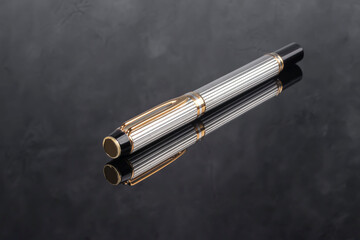 A branded fountain pen next to a box. Gift set. Selective focus. Office interior