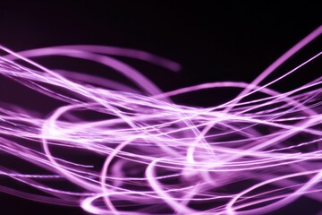 Abstract neon purple light trails on dark background