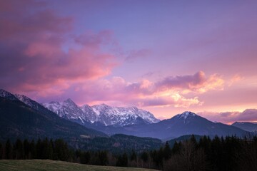 Majestic sunset over snow-capped mountains and forested valley