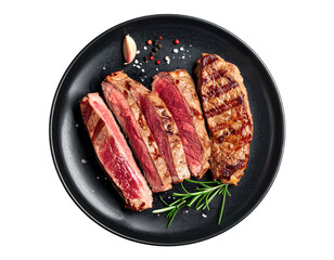 Sliced, seared steak on a dark plate, garnished with rosemary and spices