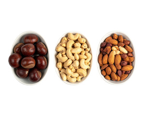 Three white bowls filled with assorted nuts isolated on a black background