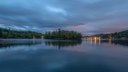 Fototapeta premium Long exposure of Beaver Lake at twilight blue hour on a cloudy summer day, highlighting reflection and ambient light, Earth Day