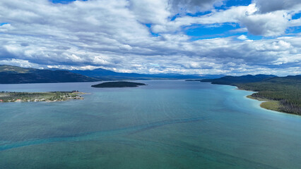 Discover peaceful lake scenery with rolling mountains and stunning cloudy skies
