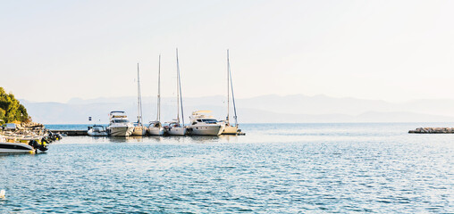 Yachts docked in upscale marina with clear blue water and sky