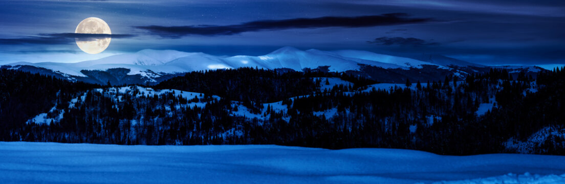 panorama of mountain ridge in winter at night. magnificent alpine landscape with snowy peaks with cloudy sky in full moon light. backdrop for fiction art or mystery concepts - Powered by Adobe