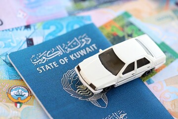 Kuwaiti dinar currency money bills and car with passport close up. The concept of car ownership