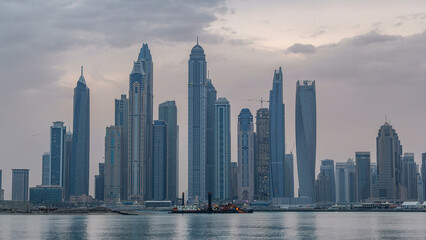 Fototapeta premium Panorama of modern skyscrapers in Dubai city night to day timelapse from the Palm Jumeirah Island.