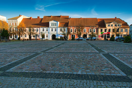Strzelce Krajeńskie (niem. Friedeberg in der Neumark) &ndash; kolorowy brukowany rynek z zabytkowymi budynkami, kawiarnią na świeżym powietrzu i aleją obsadzoną drzewami o zachodzie słońca.