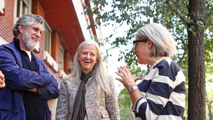 Senior friends talking and laughing outdoors