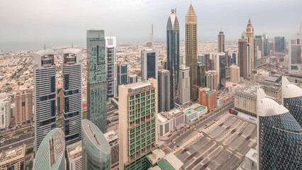 Obraz premium Skyline of the buildings of Sheikh Zayed Road and DIFC aerial night to day timelapse in Dubai, UAE.