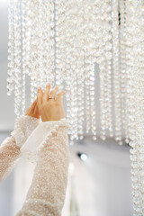 Elegantly adjusting a sparkling chandelier in soft light