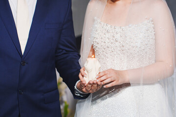 Couple with candle at bright wedding ceremony