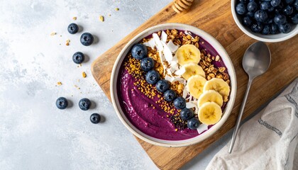 Acai breakfast superfoods smoothies bowl topped with bee pollen granola coconut flakes and blueberries. Overhead top view flat lay © Mazouni