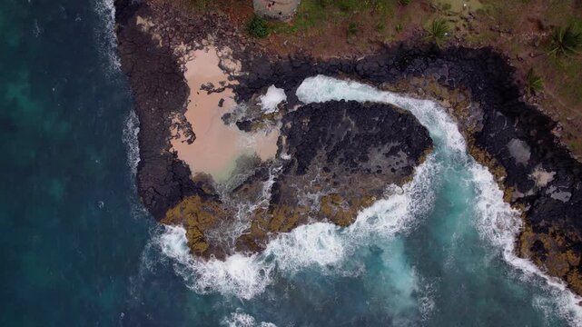 Basalt cliffs roar at Boca do Inferno, &Aacute;gua Iz&eacute;, S&atilde;o Tom&eacute; &mdash; a dramatic viewpoint where waves crash through narrow volcanic cave arch that causes blowhole or hellhole.