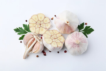 Garlic, peppercorns and parsley on white table, flat lay