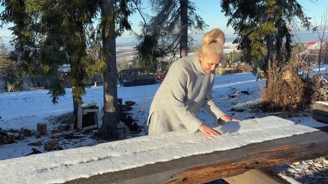 Woman drawing handprints on fresh snow