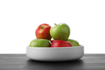 Red and green ripe apples in bowl on wooden table against white background