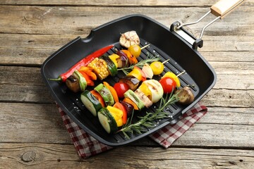 Grill pan with tasty vegetables on wooden table, closeup