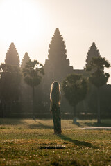 Woman watching sunrise at ancient angkor wat temple