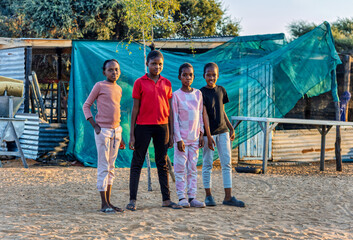 Village African Children group in front of a shack, at sunset, standing in the yard