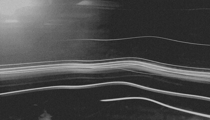 Abstract black and white image featuring streaks of light across a dark background