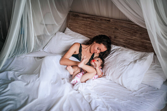 Mother and child relaxing in a cozy bedroom setting