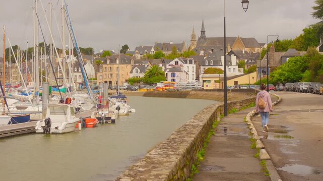 Scenic Promenade At Port Of Saint-Goustan In Brittany, France, With Docked Sailboats And Historic Buildings On Cloudy Day. wide shot