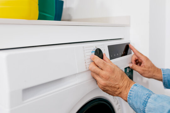Man adjusting washing machine settings for laundry