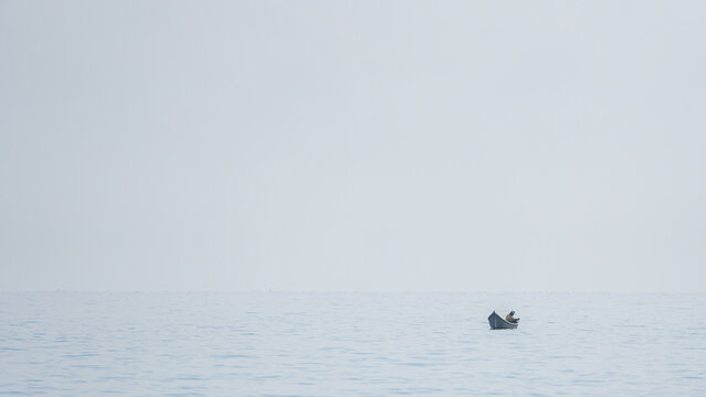 Caribbean person paddling a canoe on calm waters