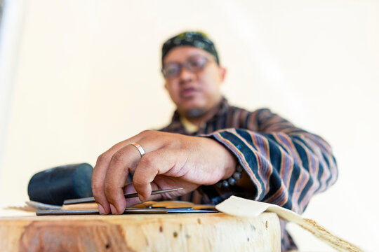 Javanese artisan working on handmade shadow puppets