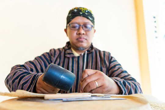 Javanese artisan working on handmade shadow puppets