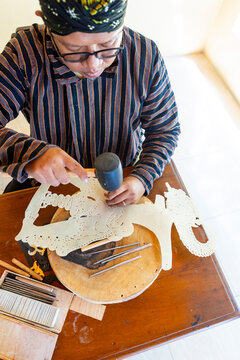 Javanese artisan crafting traditional wayang kulit puppets