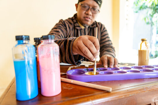 Traditional Artist Mixing Paints for Wayang Kulit Puppet Craft