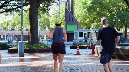 名古屋の栄の市街の公園でランニングする外国人男女の姿