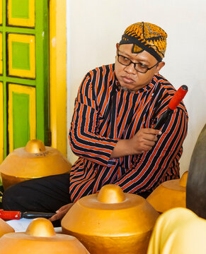 Traditional Javanese gamelan musician playing percussion