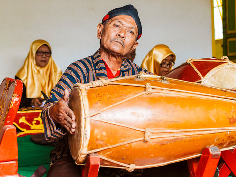 Traditional Javanese musician playing a gamelan drum