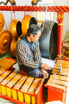 Traditional Javanese musician playing gamelan instruments