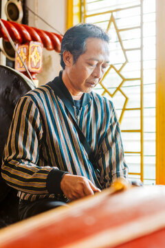 Musician playing traditional Javanese gamelan instrument