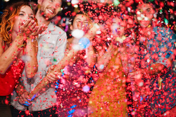 Happy friends celebrating with confetti new year's eve inside disco club - Party concept - Soft focus on left girl face © DisobeyArt