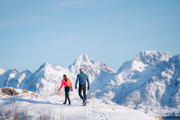 Couple exploring snowy Lofoten landscape in winter